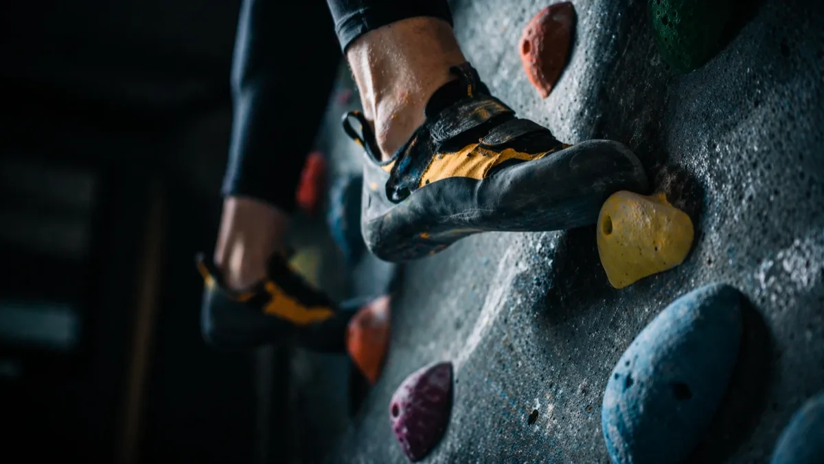 Buty wspinaczkowe precyzyjnie ustawione na chwytach boulderowych — technika stóp