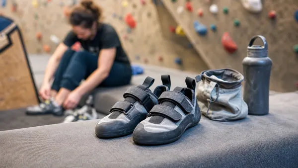 Neutralne buty wspinaczkowe na macie w boulderowni obok woreczka na magnezję