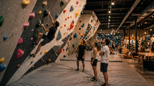 Boulderownia w Warszawie — panel ze wspinaczami na kolorowych chwytach